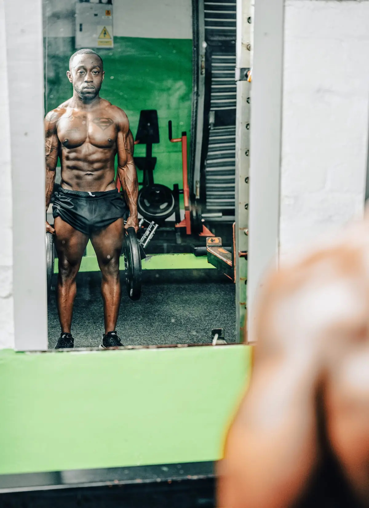 Jovan Johnson holding weight plates during a gym training session